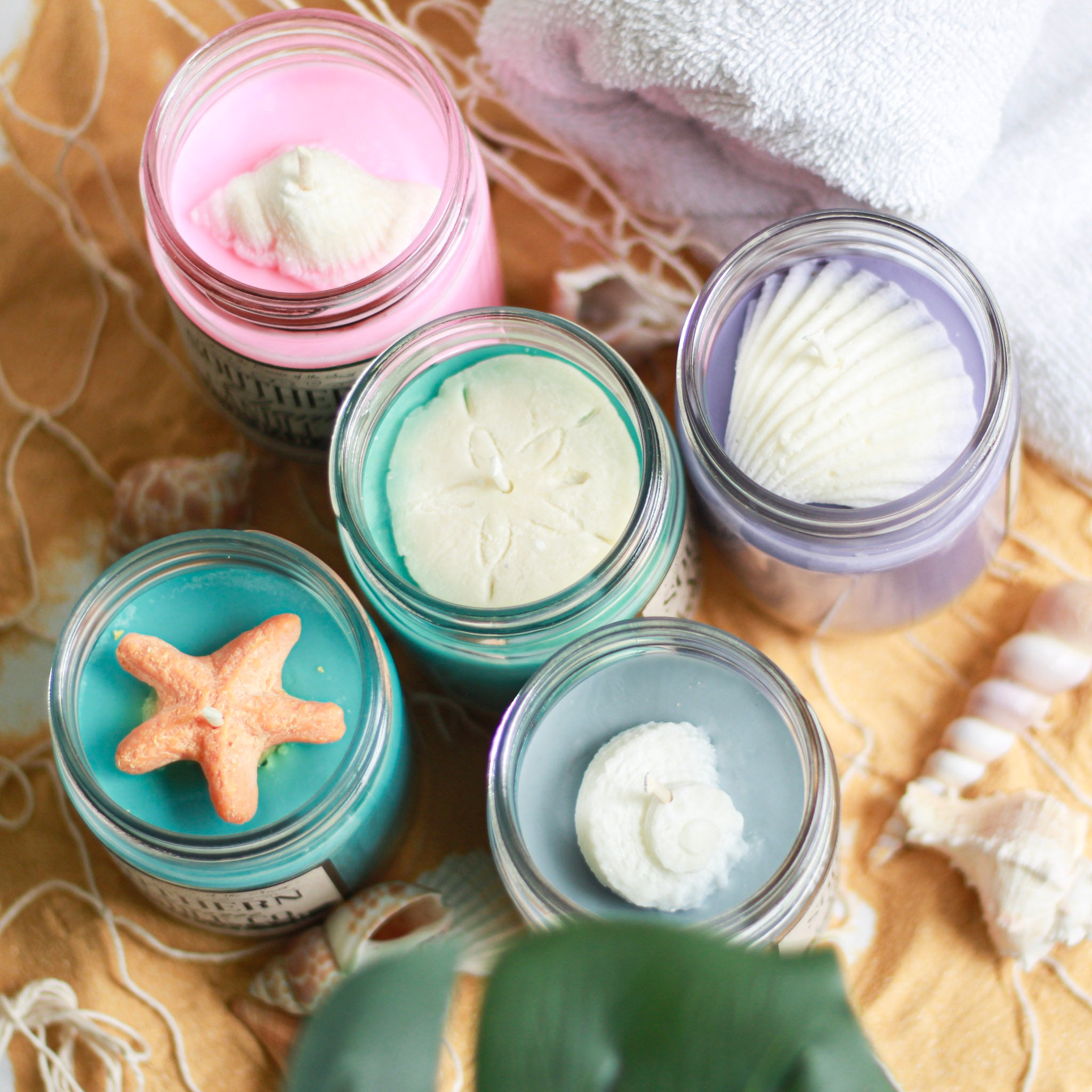 Hand poured soy wax candles with beach inspired wax sea shells on top.